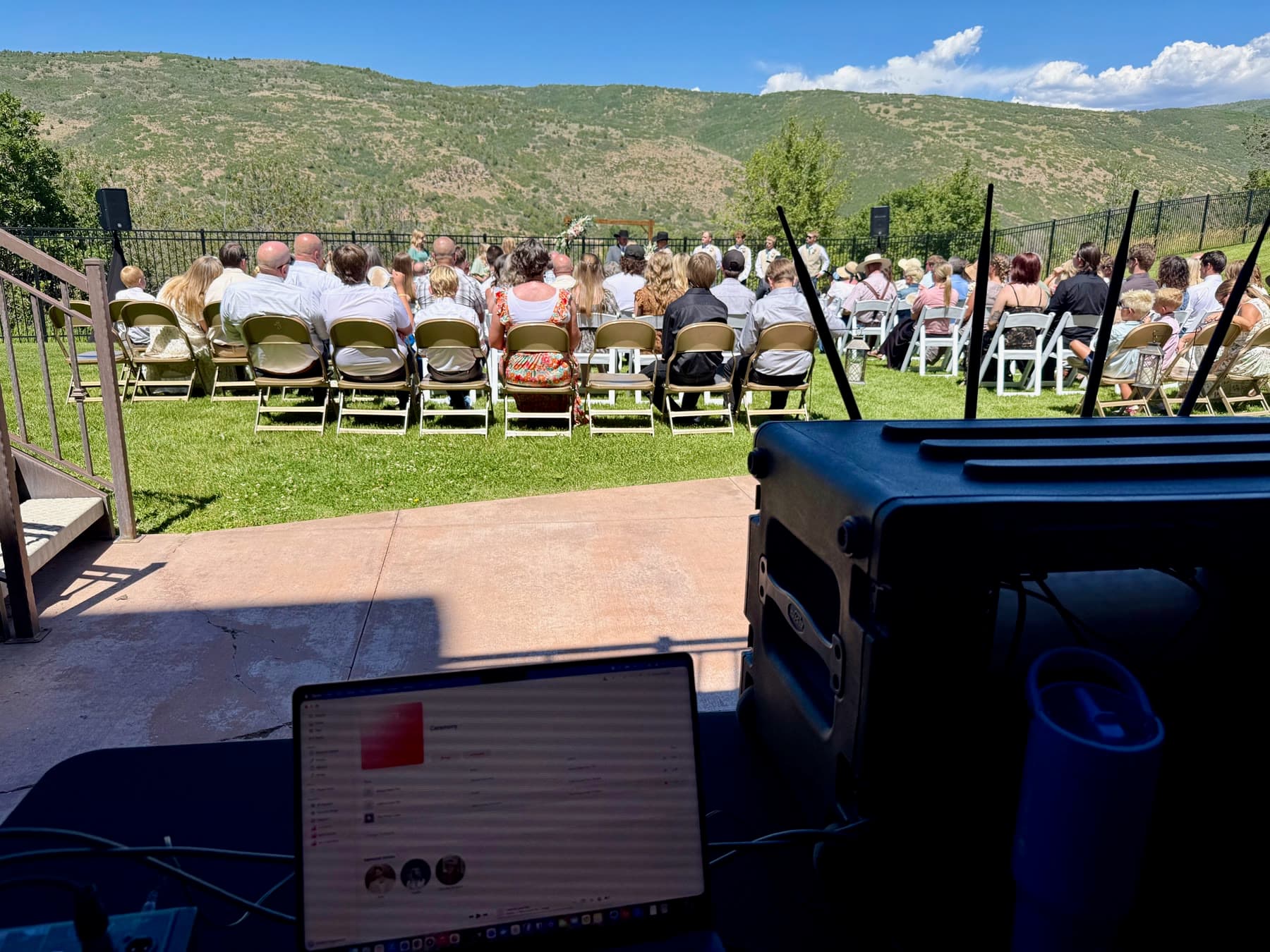 Outdoor wedding ceremony with mountain views and Frostline Audio speakers set for guest coverage